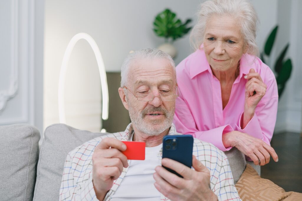 an elderly couple looking at a phone