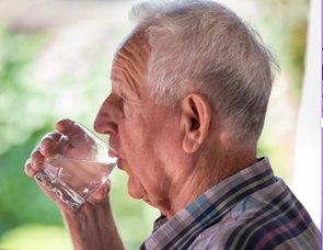 Elderly man drinking water from glass.